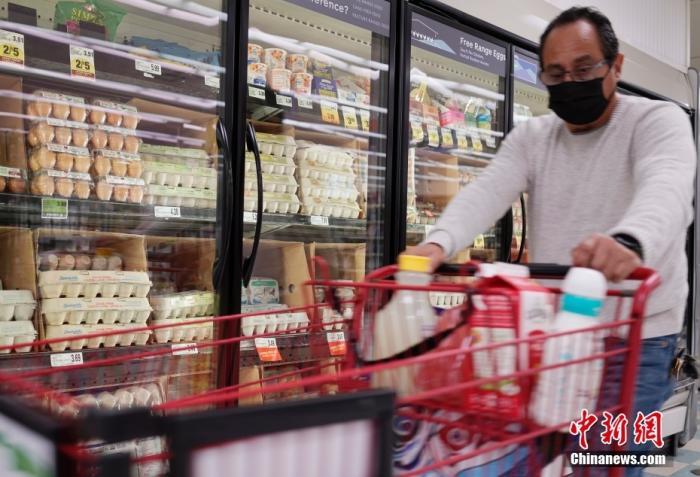 资料图：一名顾客从美国加州圣马特奥县一家超市的鸡蛋货柜前经过。 中新社记者 刘关关 摄